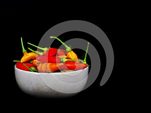 freshÃ¢â¬â¹ chilliÃ¢â¬â¹ inÃ¢â¬â¹ ceramicÃ¢â¬â¹ cupÃ¢â¬â¹ onÃ¢â¬â¹ blackÃ¢â¬â¹ backgroundÃ¢â¬â¹ photo